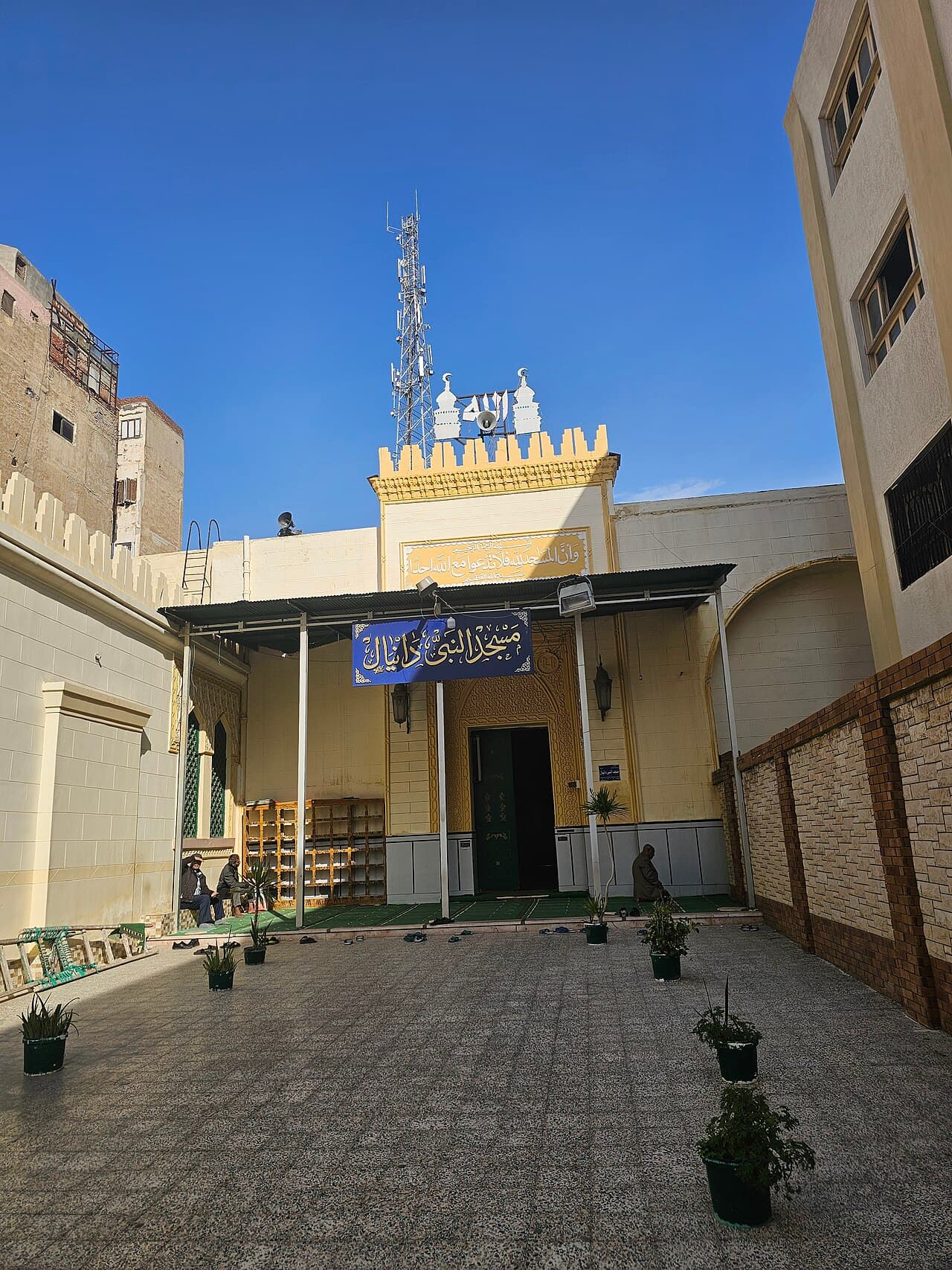 صحن مسجد النبي دانيال ولافتته الزرقاء فوق المدخل