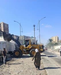 لودر وسيارة نقل أثناء رفع الرديم