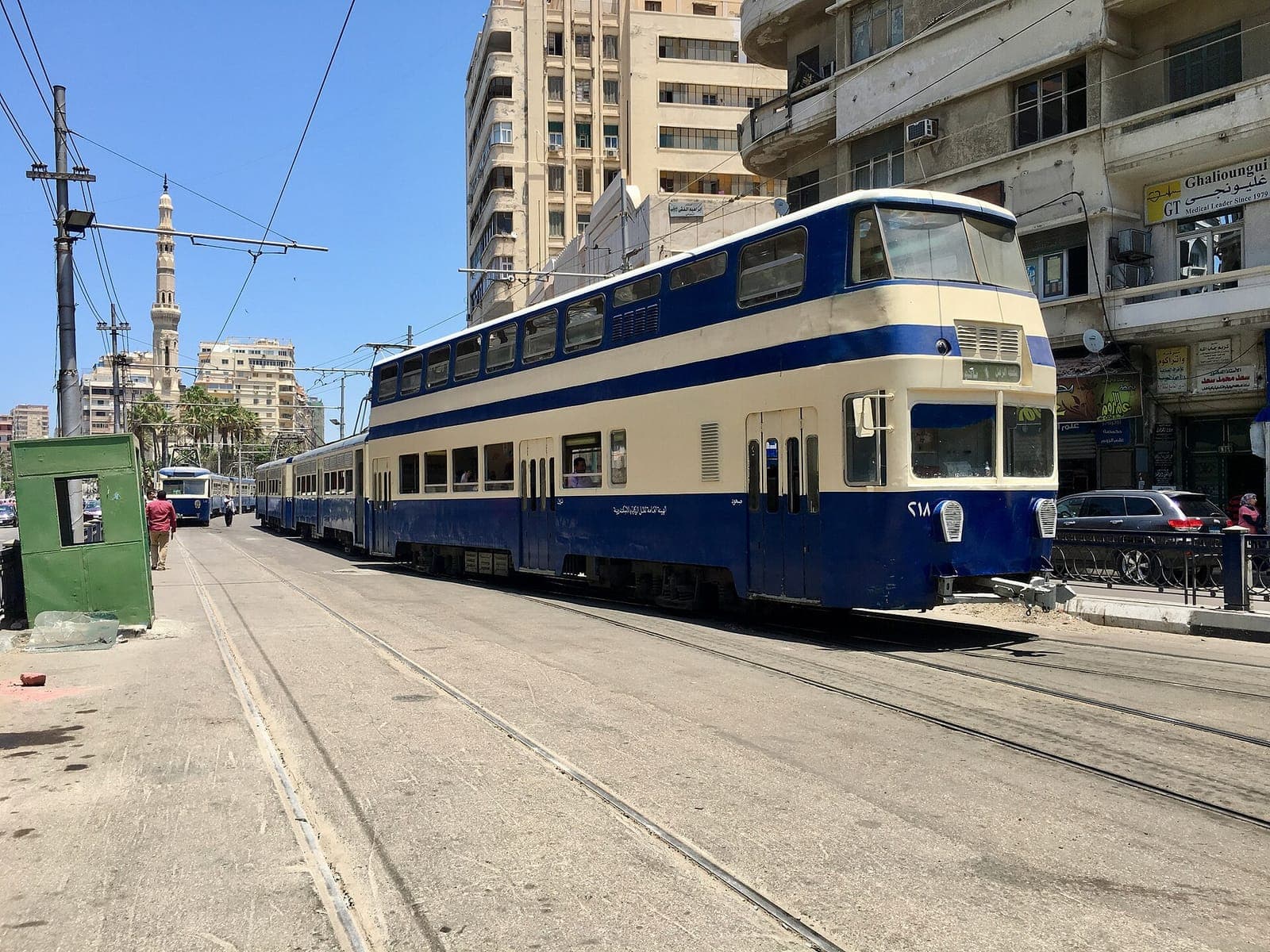 ترام الرمل الأزرق ذو الطابقين (العربة رقم 218) يقترب من إحدى المحطات في الإسكندرية.